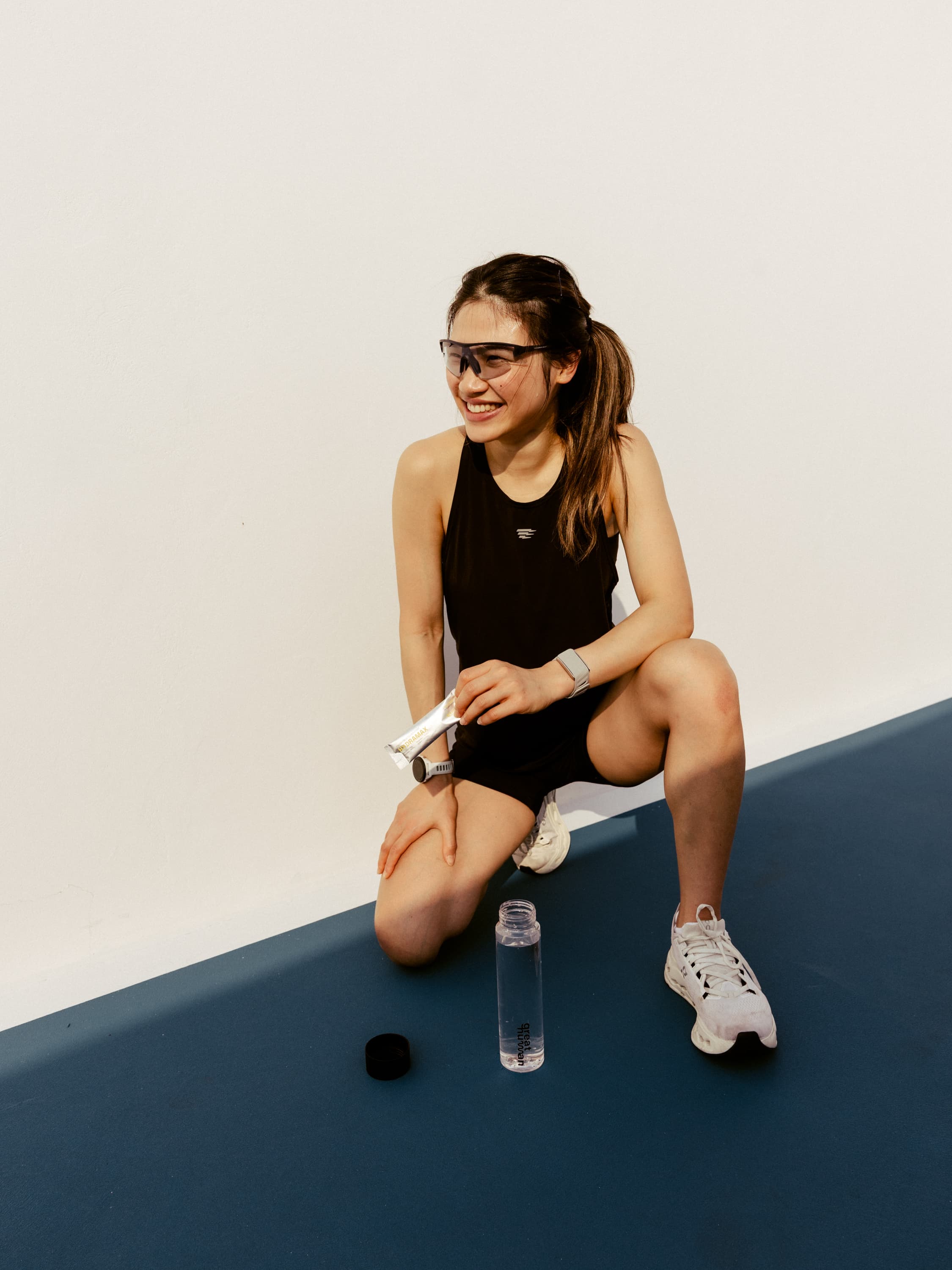 Athlete kneeling with a HYDRAMAX sachet and Great Human bottle